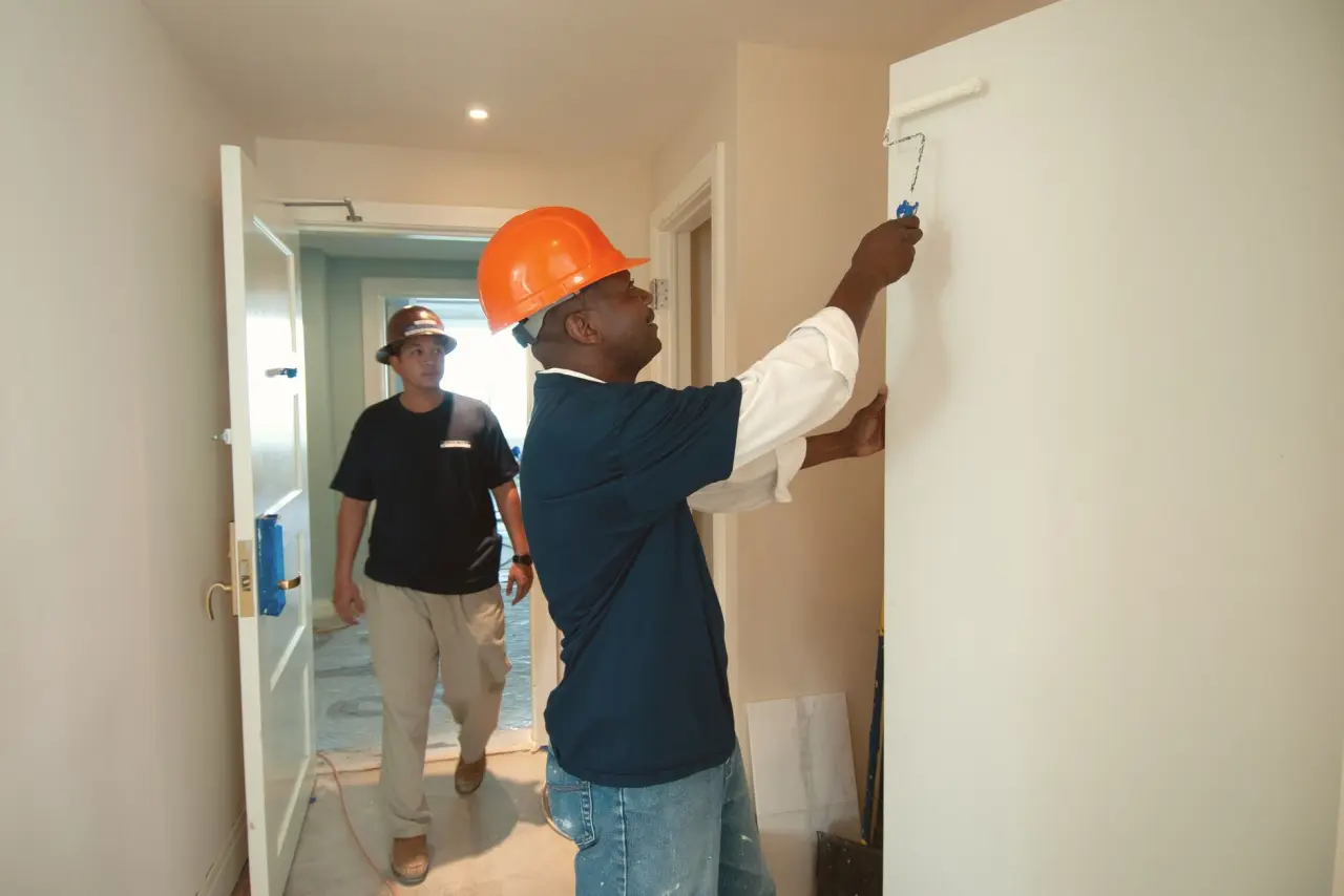 Peintre appliquant une finition au rouleau sur un mur intérieur clair